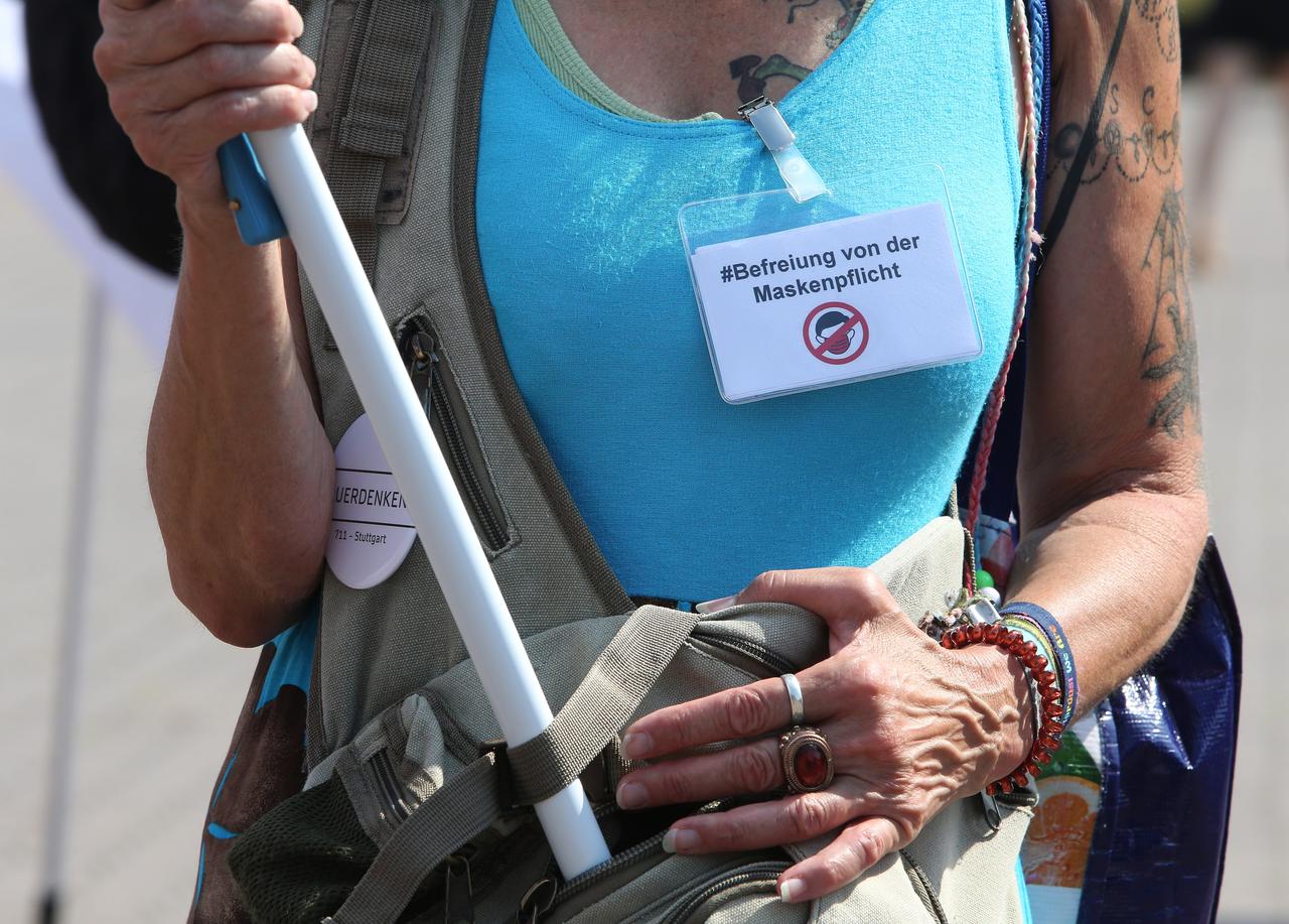 Eine Demonstrantin auf einer "Hygienedemo" in Berlin trägt ein Schild auf dem T-Shirt mit der Aufschrift "#Befreiung der Maskenpflicht" und ein "Querdenken"-Button an ihrem Rucksack. Eine Demonstrantin auf einer "Hygienedemo" in Berlin trägt ein Schild auf dem T-Shirt mit der Aufschrift "#Befreiung der Maskenpflicht" und ein "Querdenken"-Button an ihrem Rucksack.
