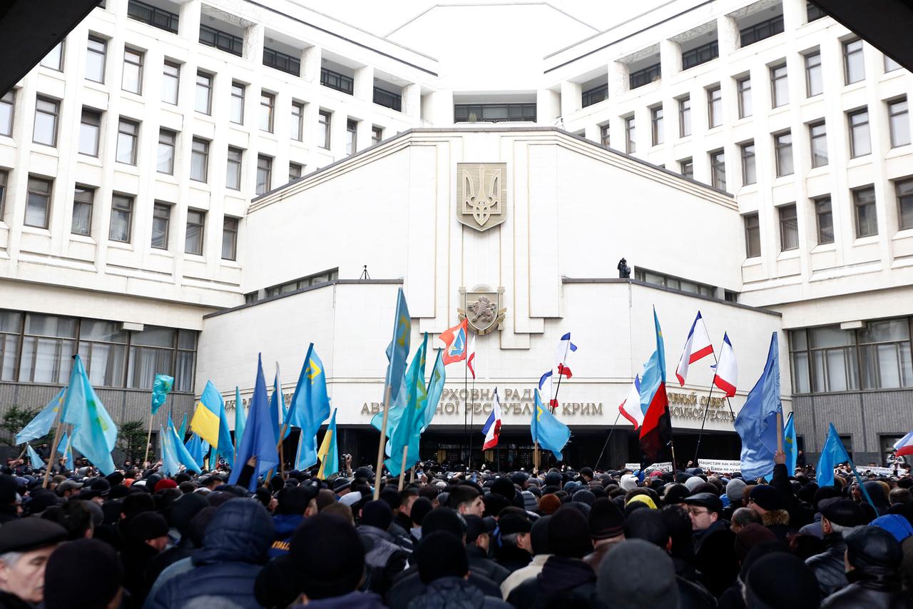 Demonstrierende unter anderem mit russischen und ukrainischen Flaggen vor dem Parlamentgebäude in Simferopol am 26. Februar 2014, vor der russischen Annexion der ukrainischen Halbinsel