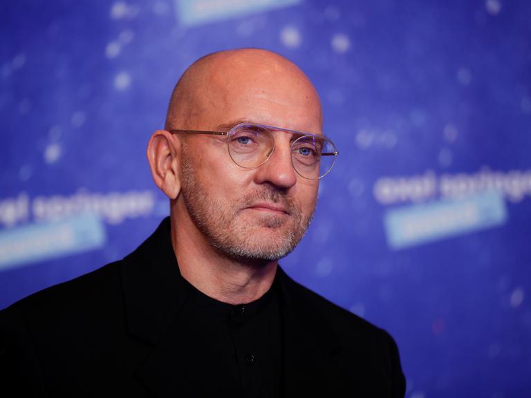 DJ Sven Väth steht bei einer Preisverleihung und schaut knapp an der Kamera vorbei.