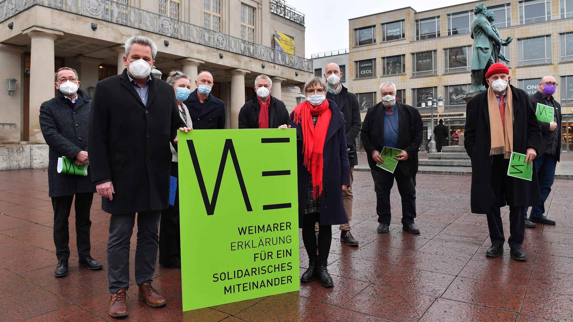 Menschen stehen auf dem Theaterplatz in Weimar mit einem Pappschild der Weimarer Erklärung Menschen stehen auf dem Theaterplatz in Weimar mit einem Pappschild der Weimarer Erklärung