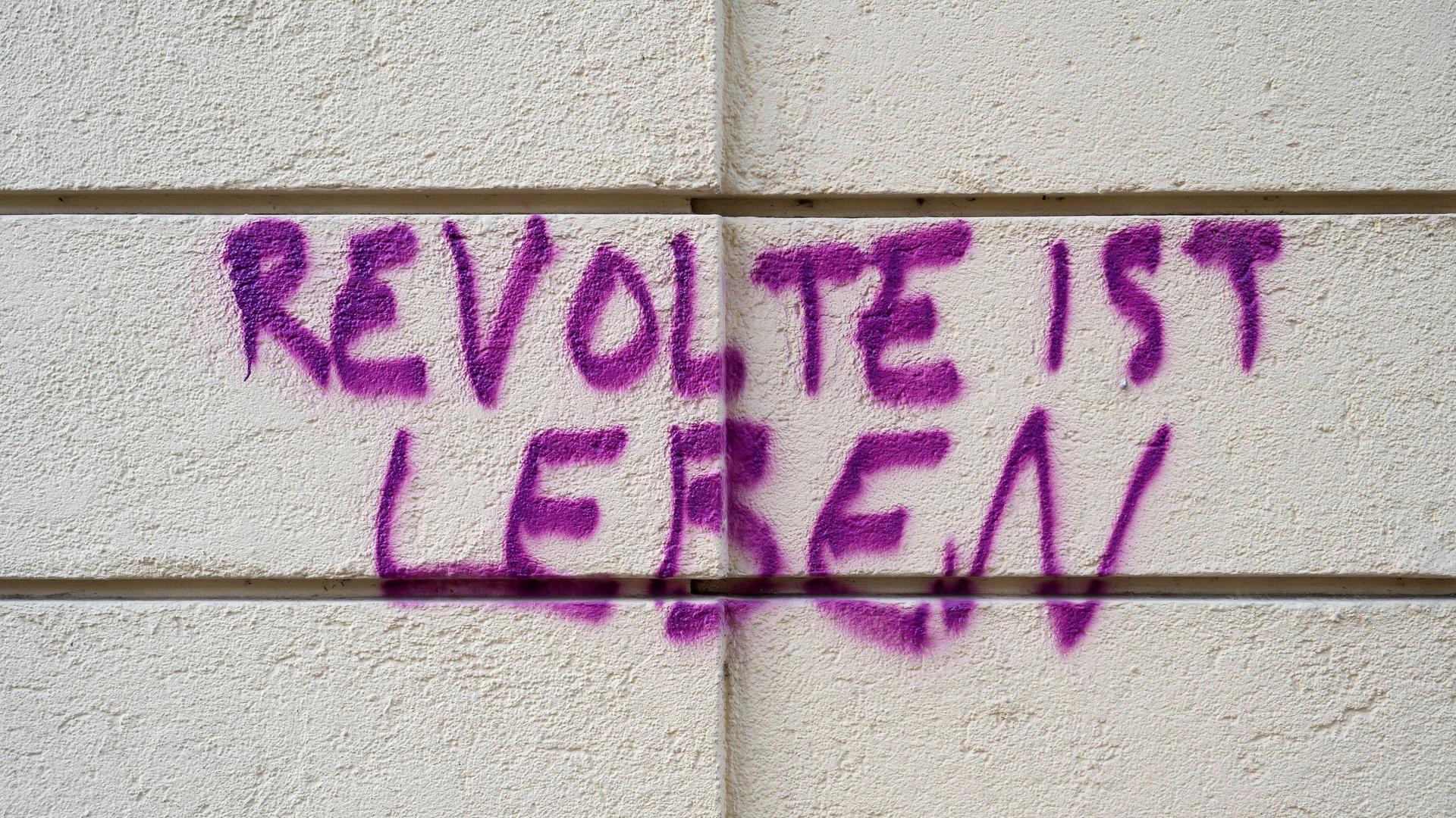 Gesprühter Schriftzug "Revolte ist Leben" auf einer Hauswand in Haidhausen