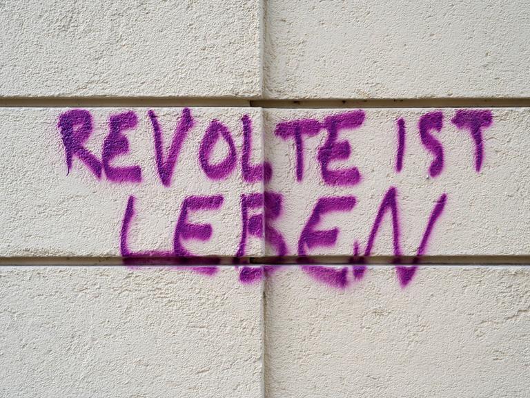 Gesprühter Schriftzug "Revolte ist Leben" auf einer Hauswand in Haidhausen