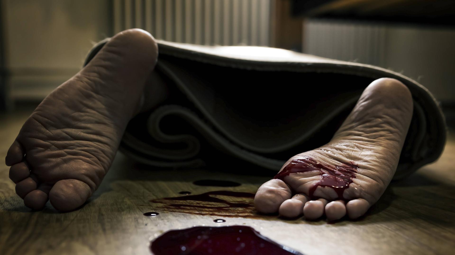 Die Füße einer Frau, davor eine Blutlache Die Füße einer Frau, davor eine Blutlache