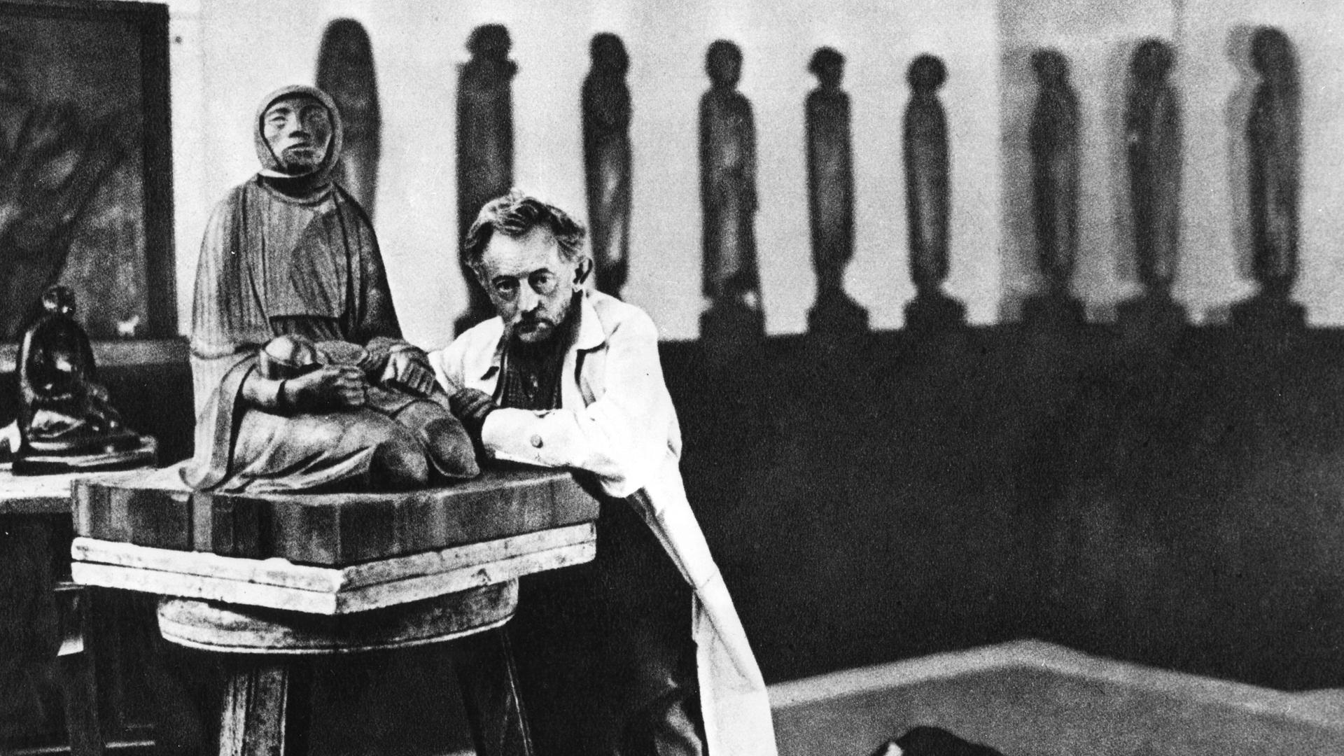 Ein älterer Herr steht in einem Atelier mit Kunstwerken. Ein älterer Herr steht in einem Atelier mit Kunstwerken.