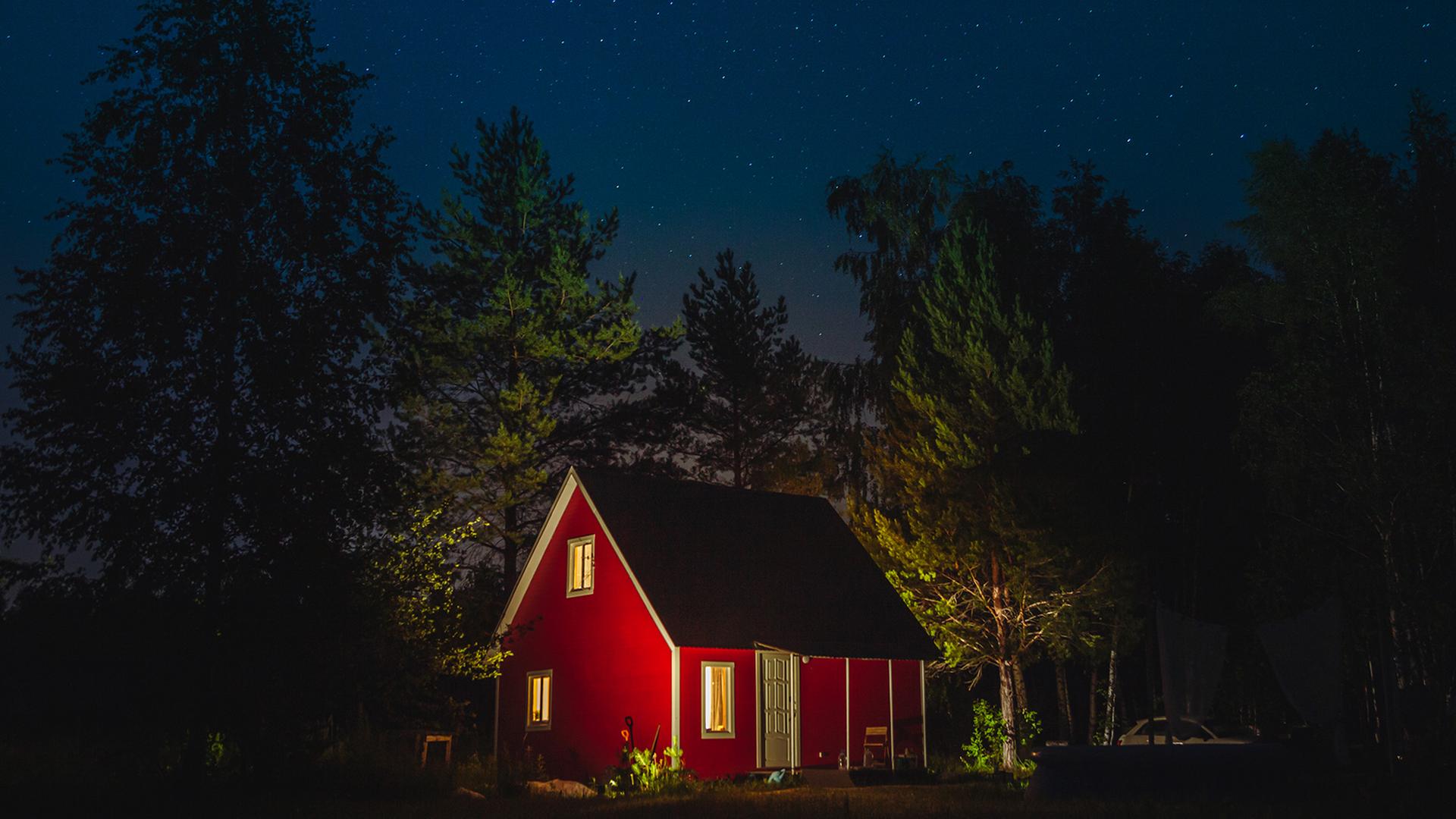Ein kleines rotes Haus bei Nacht in einem Wald. Ein kleines rotes Haus bei Nacht in einem Wald.