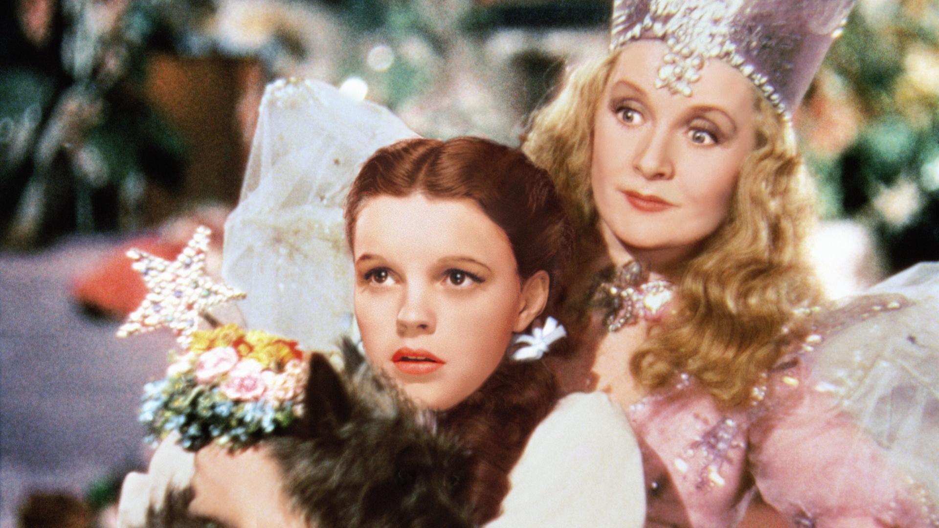 In dem Szenenbild von "Der Zauberer von Oz" schaut Judy Garland in der Rolle der "Dorothy" gebannt nach vorn, hinter ihr steht Billie Burke als 'Glinda'. In dem Szenenbild von "Der Zauberer von Oz" schaut Judy Garland in der Rolle der "Dorothy" gebannt nach vorn, hinter ihr steht Billie Burke als 'Glinda'.