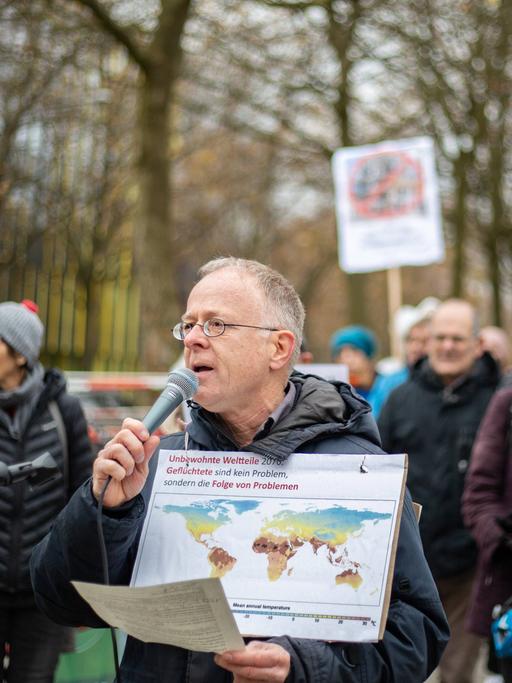 Jörg Alt spricht bei einer Demo vor dem Tagungshotel der Innenministerkonferenz in Solidarität mit der Letzten Generation und für Klimaschutz in München in ein Mikrofon.