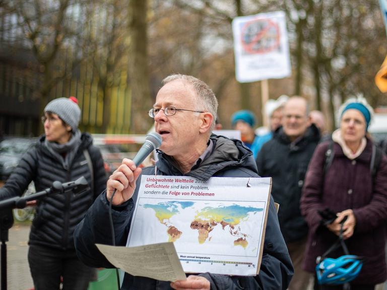 Jörg Alt spricht bei einer Demo vor dem Tagungshotel der Innenministerkonferenz in Solidarität mit der Letzten Generation und für Klimaschutz in München in ein Mikrofon.