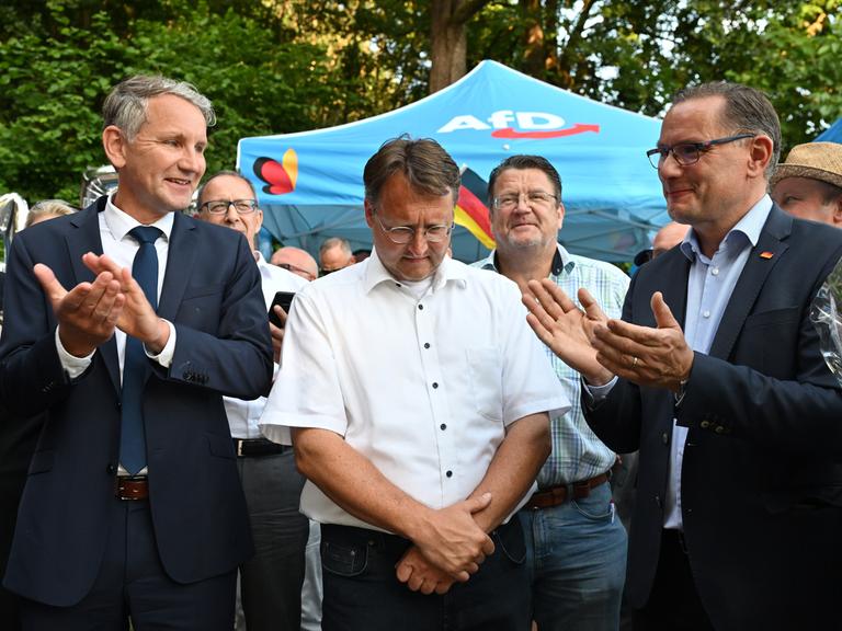Björn Höcke (l), Landessprecher und Fraktionsvorsitzender der AfD in Thüringen, Landratswahlkandidat Robert Sesselmann (AfD, 2.v.l.), Stephan Brandner (AfD, 3.v.l.), AfD Bundestagsabgeordneter aus Thüringen, und Tino Chrupalla (AfD, vorne r) , AfD-Bundesvorsitzender und Fraktionsvorsitzender der AfD, stehen im Garten eines Restaurants bei der AfD-Wahlparty. Die AfD hat erstmals in Deutschland eine Landratswahl gewonnen. Ihr Kandidat Robert Sesselmann setzte sich im Thüringer Kreis Sonneberg in der Stichwahl gegen den amtierenden Landrat Köpper von der CDU durch.