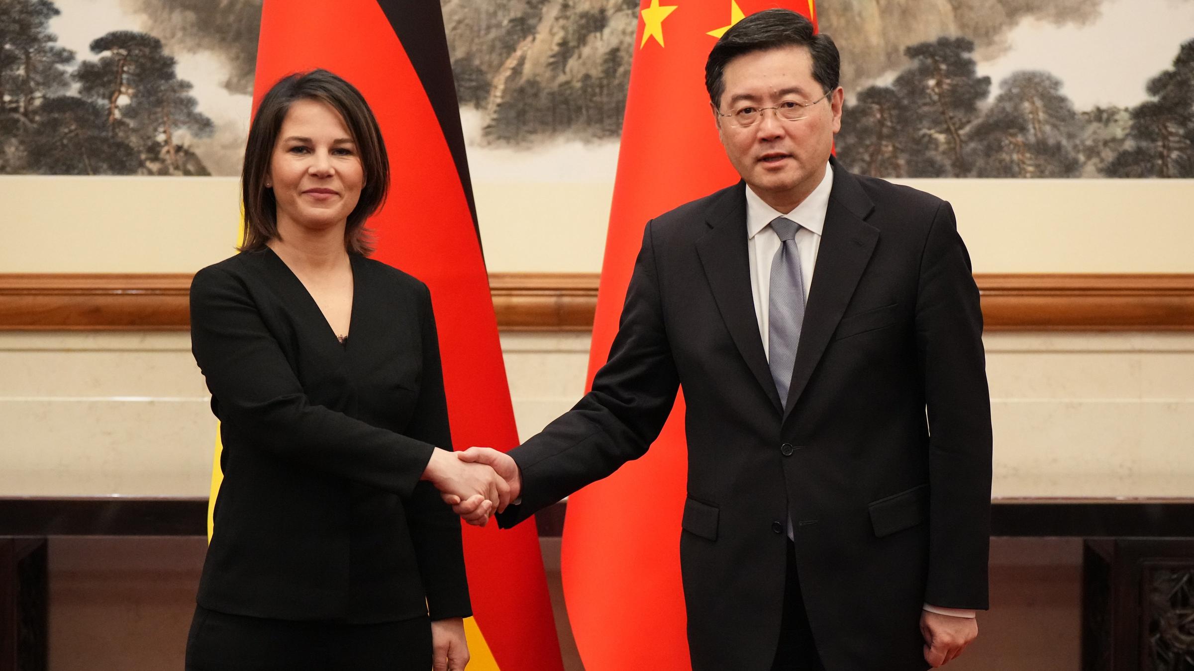Peking: Außenministerin Annalena Baerbock und der chinesische Außenminister Qin Gang geben sich im Staatsgästehaus Diaoyutai vor Beginn des deutsch-chinesischen Strategischen Dialogs die Hand. Hinter ihnen die deutsche und die chinesische Flagge.