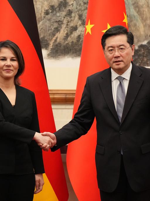 Peking: Außenministerin Annalena Baerbock und der chinesische Außenminister Qin Gang geben sich im Staatsgästehaus Diaoyutai vor Beginn des deutsch-chinesischen Strategischen Dialogs die Hand. Hinter ihnen die deutsche und die chinesische Flagge.