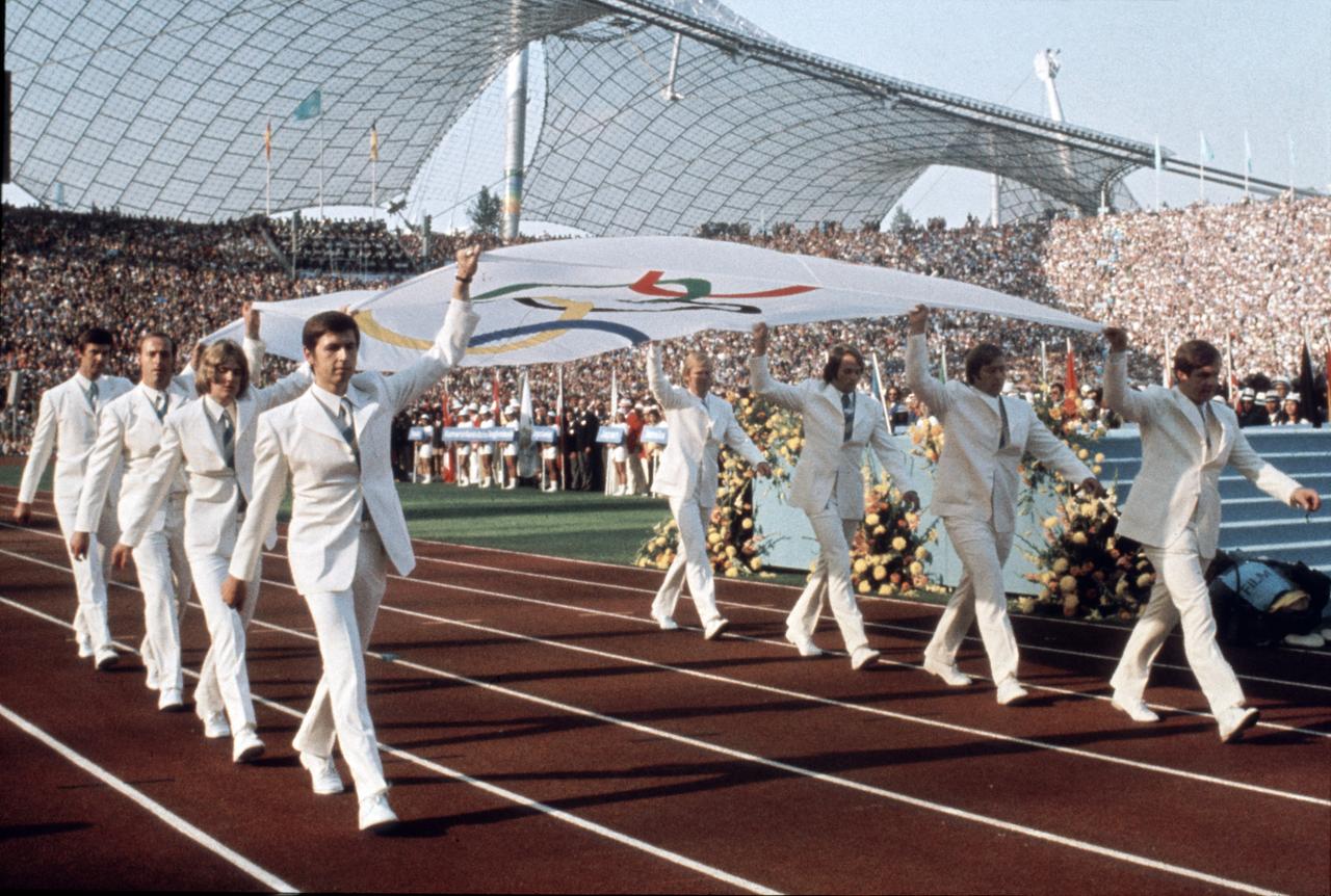 Die Mannschaft des deutschen Gold-Achter (Rudern) von Mexiko 1968 trägt die Olympische Fahne feierlich ins Stadion: (l-r): Egbert Hirschfelder, Rüdiger Henning, Steuermann Gunther Tiersch, Schlagmann Horst Meyer, Jörg Siebert, Roland Böse, Niko Ott und Dirk Schreyer. Blick in das Münchener Olympiastadion während der Eröffnungsfeier der Olympischen Sommerspiele am 26. August 1972. Die Mannschaft des deutschen Gold-Achter (Rudern) von Mexiko 1968 trägt die Olympische Fahne feierlich ins Stadion: (l-r): Egbert Hirschfelder, Rüdiger Henning, Steuermann Gunther Tiersch, Schlagmann Horst Meyer, Jörg Siebert, Roland Böse, Niko Ott und Dirk Schreyer. Blick in das Münchener Olympiastadion während der Eröffnungsfeier der Olympischen Sommerspiele am 26. August 1972.