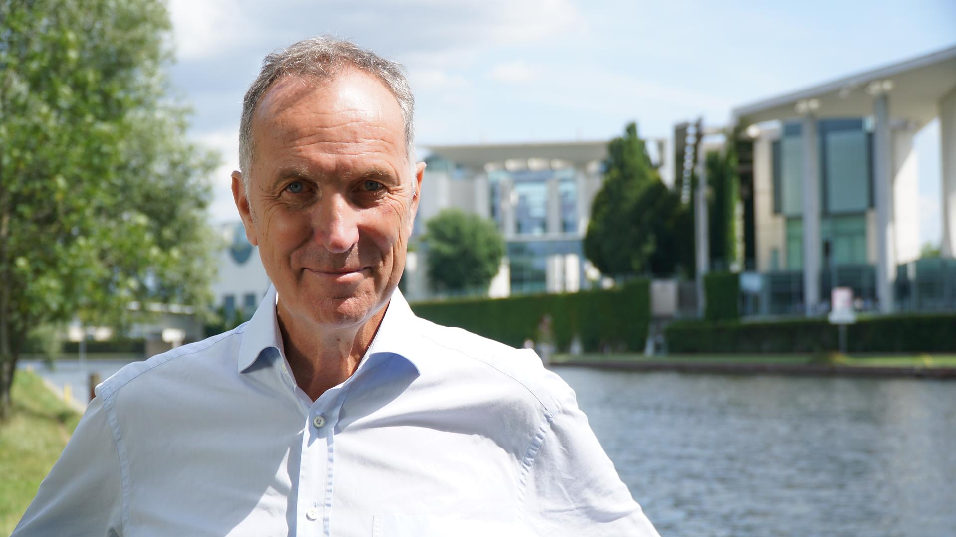 Portrait des Journalisten Stephan Lamby vor einem Stadtpanorama mit Fluss Portrait des Journalisten Stephan Lamby vor einem Stadtpanorama mit Fluss