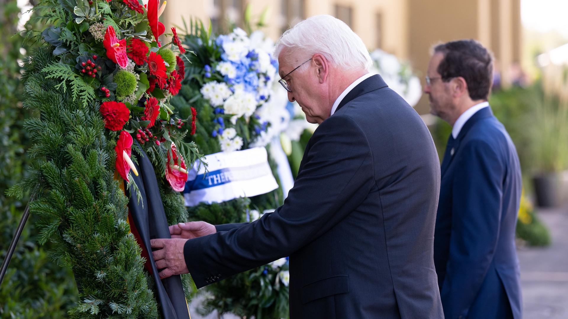 Bundes-Präsident Steinmeier und der israelische Staats-Chef Herzog stehen mit gesenktem kopf vor Blumen-Kränzen. Bundes-Präsident Steinmeier und der israelische Staats-Chef Herzog stehen mit gesenktem kopf vor Blumen-Kränzen.