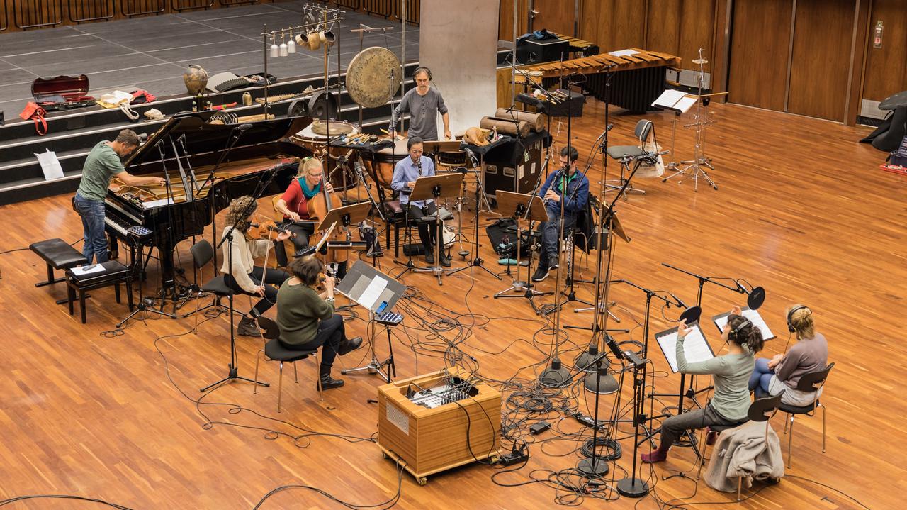 Viele Musiker sitzen zwischen im Sendesaal, zwischen ihnen Mikrofone und Kabel, während sie spielen und agieren. Viele Musiker sitzen zwischen im Sendesaal, zwischen ihnen Mikrofone und Kabel, während sie spielen und agieren.