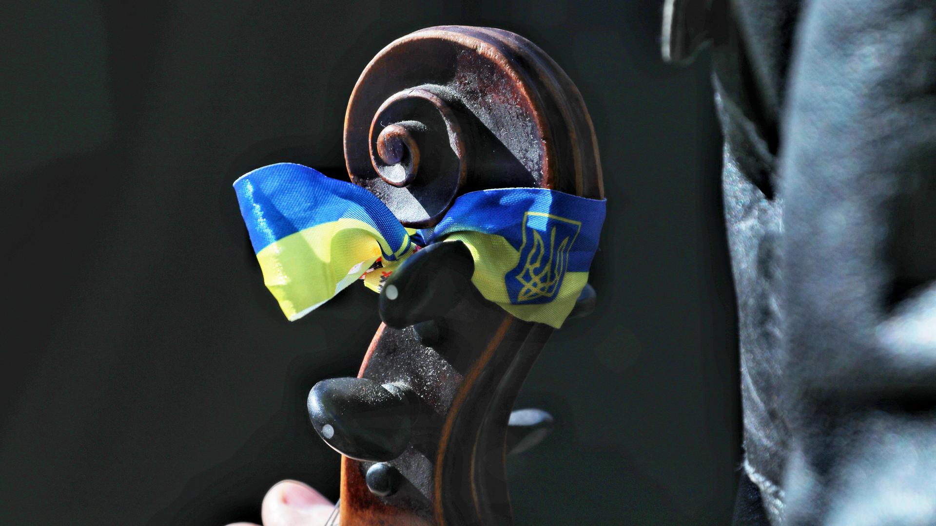 Die ukrainische Flagge ist auf einem Cello-Griffbrett angebracht. Es ist ein Solidaritätskonzert in Odessa. Die ukrainische Flagge ist auf einem Cello-Griffbrett angebracht. Es ist ein Solidaritätskonzert in Odessa.