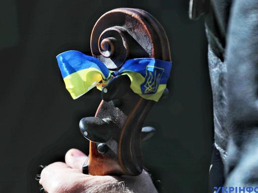 Die ukrainische Flagge ist auf einem Cello-Griffbrett angebracht. Es ist ein Solidaritätskonzert in Odessa.