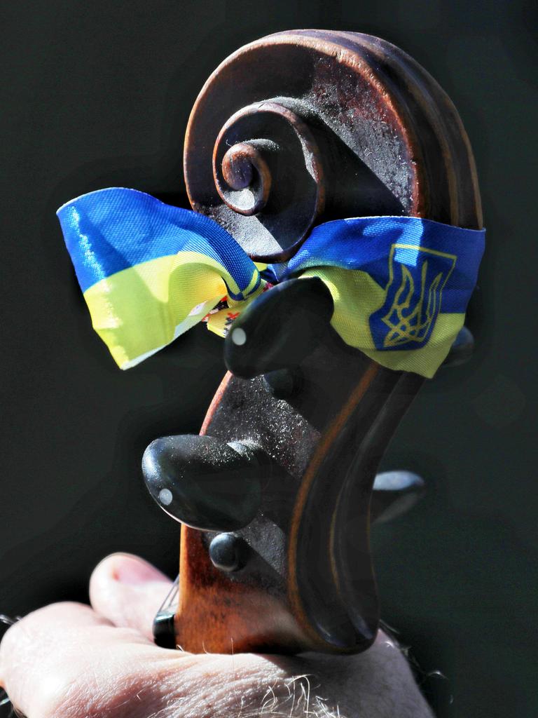Die ukrainische Flagge ist auf einem Cello-Griffbrett angebracht. Es ist ein Solidaritätskonzert in Odessa. Die ukrainische Flagge ist auf einem Cello-Griffbrett angebracht. Es ist ein Solidaritätskonzert in Odessa.