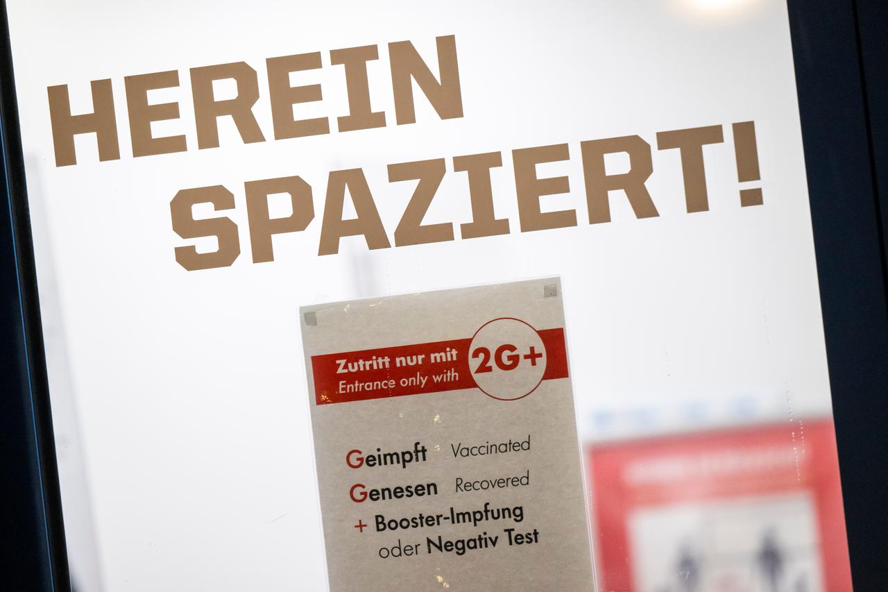 Ein Schild mit der Aufschrift "Zutritt nur mit 2Gplus - Geimpft / Genesen / plus Booster-Impfung oder Negativ Test" hängt am Kassenhaus des Deutschen Museum unter dem Schriftzug "Herein Spaziert!"