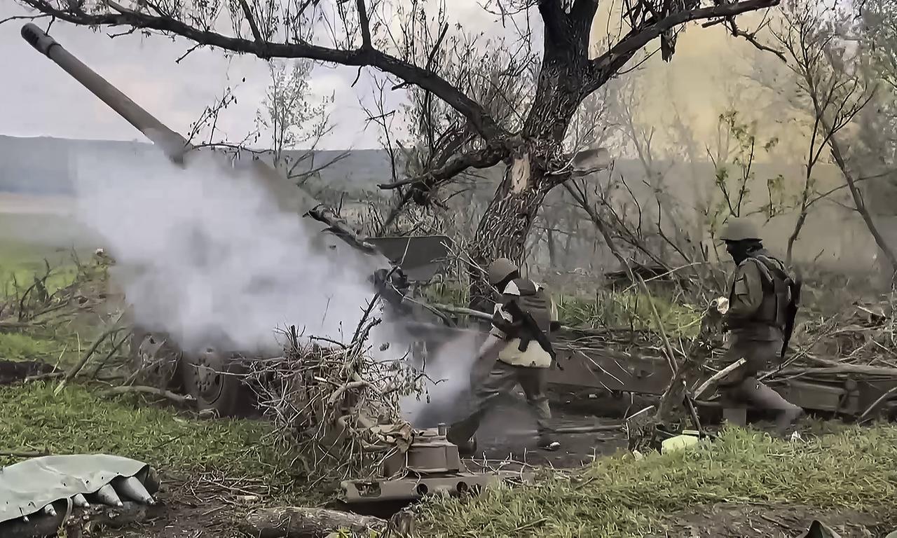 Die Soldaten und die Haubitze sind unter einem Baum, aus dem Rohr wird rauch ausgestoßen. Die Soldaten und die Haubitze sind unter einem Baum, aus dem Rohr wird rauch ausgestoßen.
