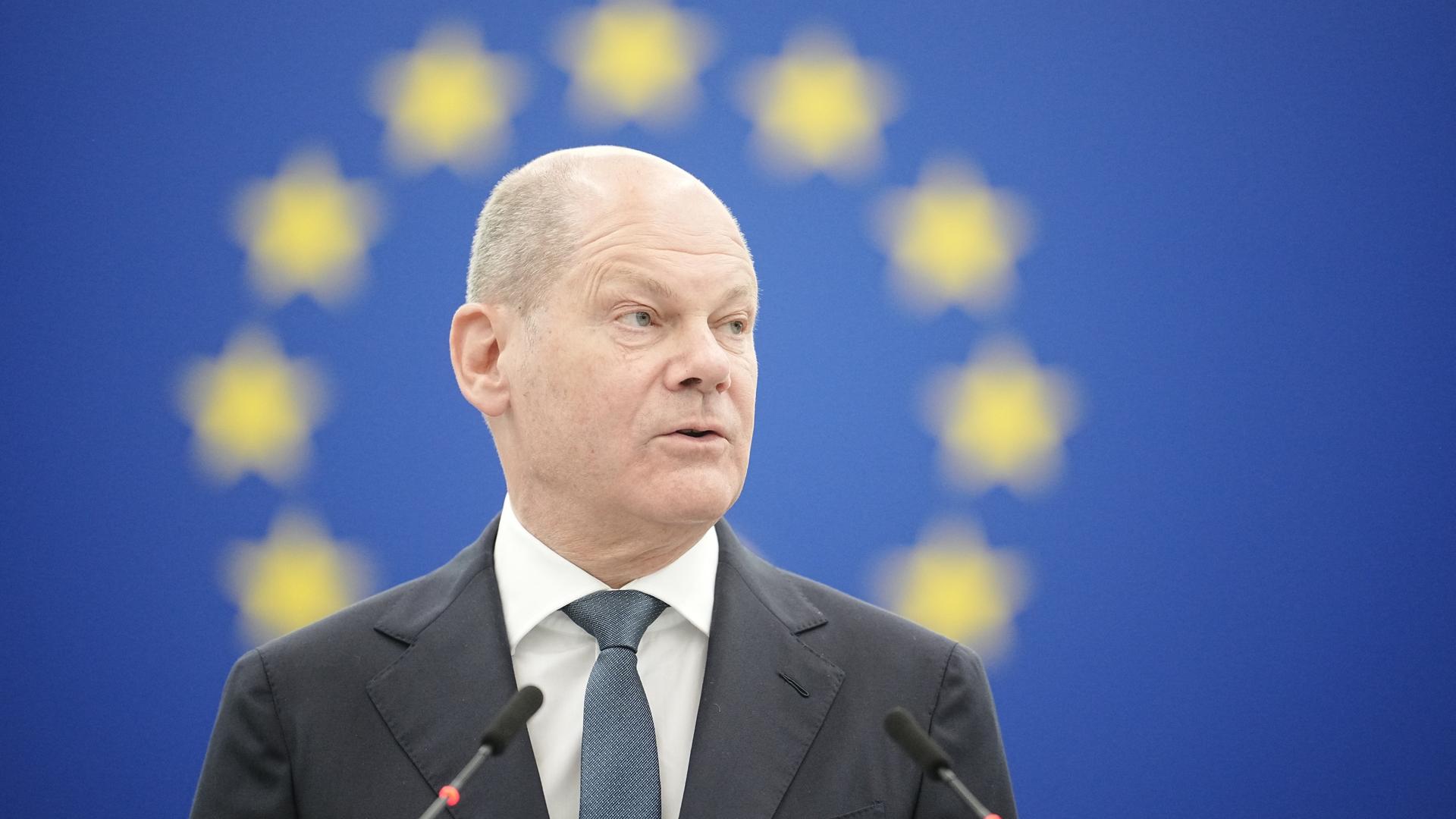 Bundeskanzler Olaf Scholz (SPD) spricht im EU-Parlament zu den Abgeordneten. Im Hintergrund das unscharfe Emblem der europäischen Gemeinschaft mit dem Kreis aus Sternen. Bundeskanzler Olaf Scholz (SPD) spricht im EU-Parlament zu den Abgeordneten. Im Hintergrund das unscharfe Emblem der europäischen Gemeinschaft mit dem Kreis aus Sternen.
