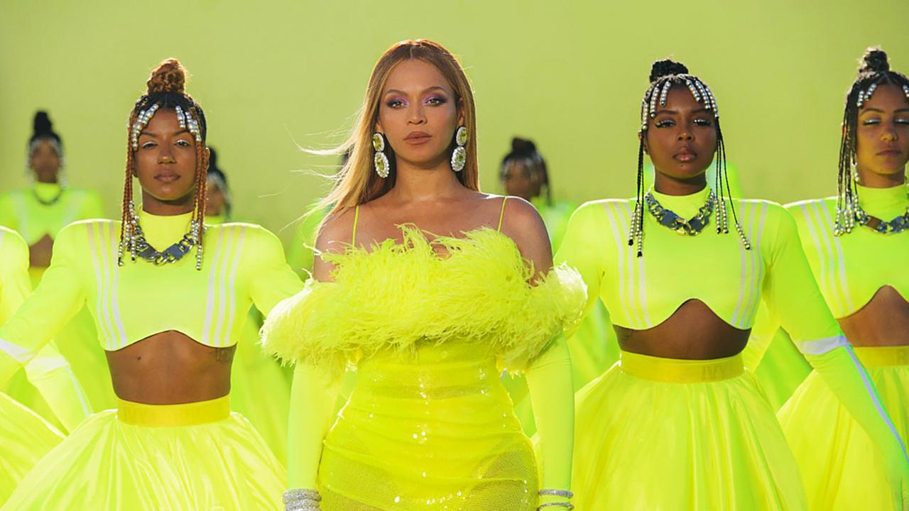 Die Sängerin Beyoncé mit ihren Tänzerinnen in neongelben Kostümen beim Bühnenauftritt. Die Sängerin Beyoncé mit ihren Tänzerinnen in neongelben Kostümen beim Bühnenauftritt.