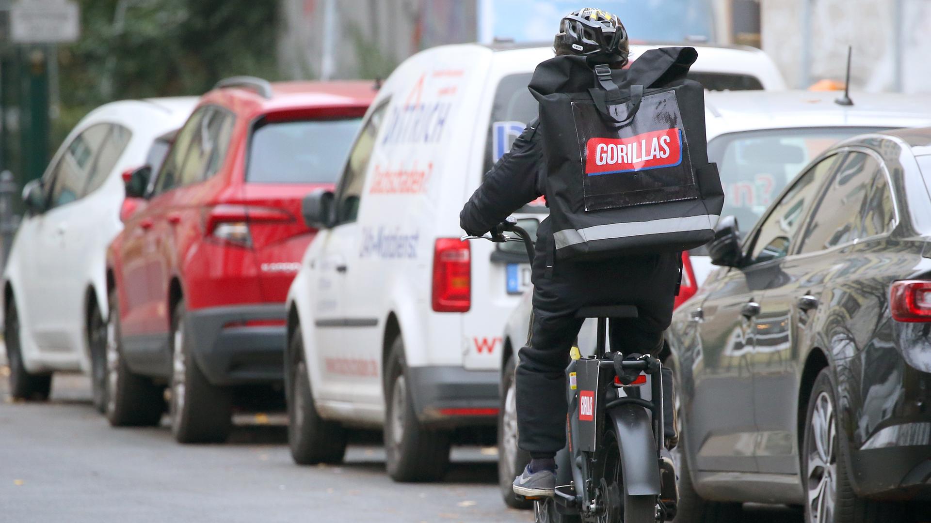 Ein Mitarbeiter des Lebensmittel Gorillas radelt durch die Straßen von Berlin. Ein Mitarbeiter des Lebensmittel Gorillas radelt durch die Straßen von Berlin.
