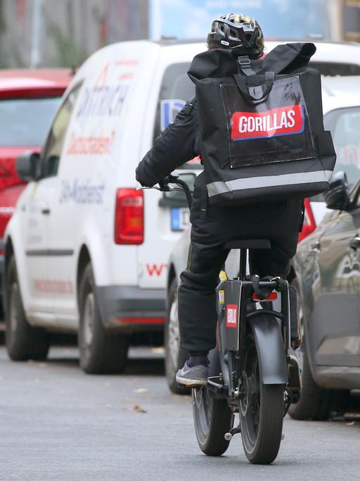 Ein Mitarbeiter des Lebensmittel Gorillas radelt durch die Straßen von Berlin. 