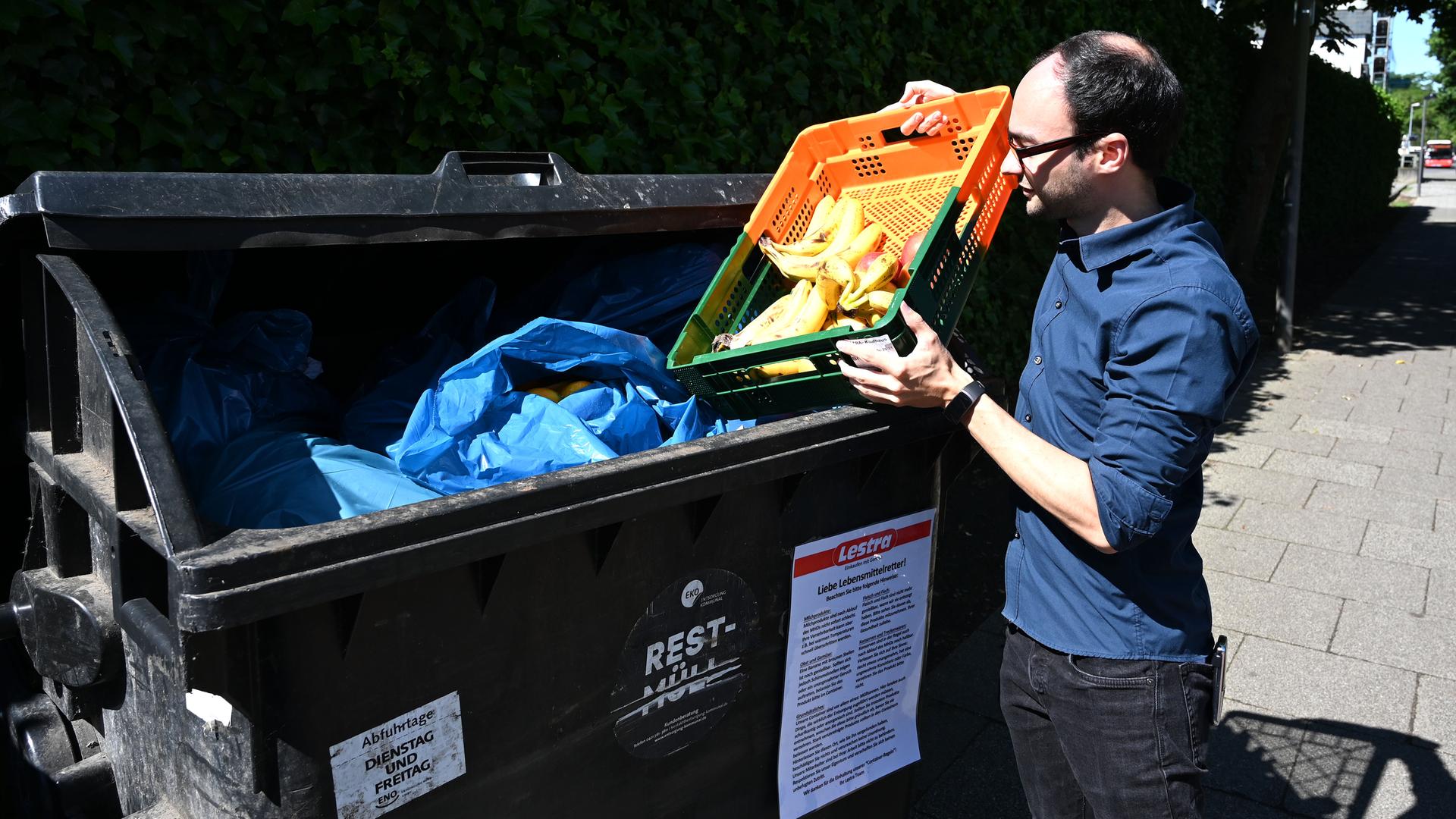 Michael Shaw, Mitarbeiter des Supermarktes Lestra, bringt Obst zu einem Container. Das sogenannte "Containern" ist hier erlaubt. An den Müllcontainern wird sogar mit einem Schild darauf hingewiesen, was voraussichtlich noch bedenkenlos gegessen werden kann und wovon man lieber die Finger lassen sollte. Michael Shaw, Mitarbeiter des Supermarktes Lestra, bringt Obst zu einem Container. Das sogenannte "Containern" ist hier erlaubt. An den Müllcontainern wird sogar mit einem Schild darauf hingewiesen, was voraussichtlich noch bedenkenlos gegessen werden kann und wovon man lieber die Finger lassen sollte.