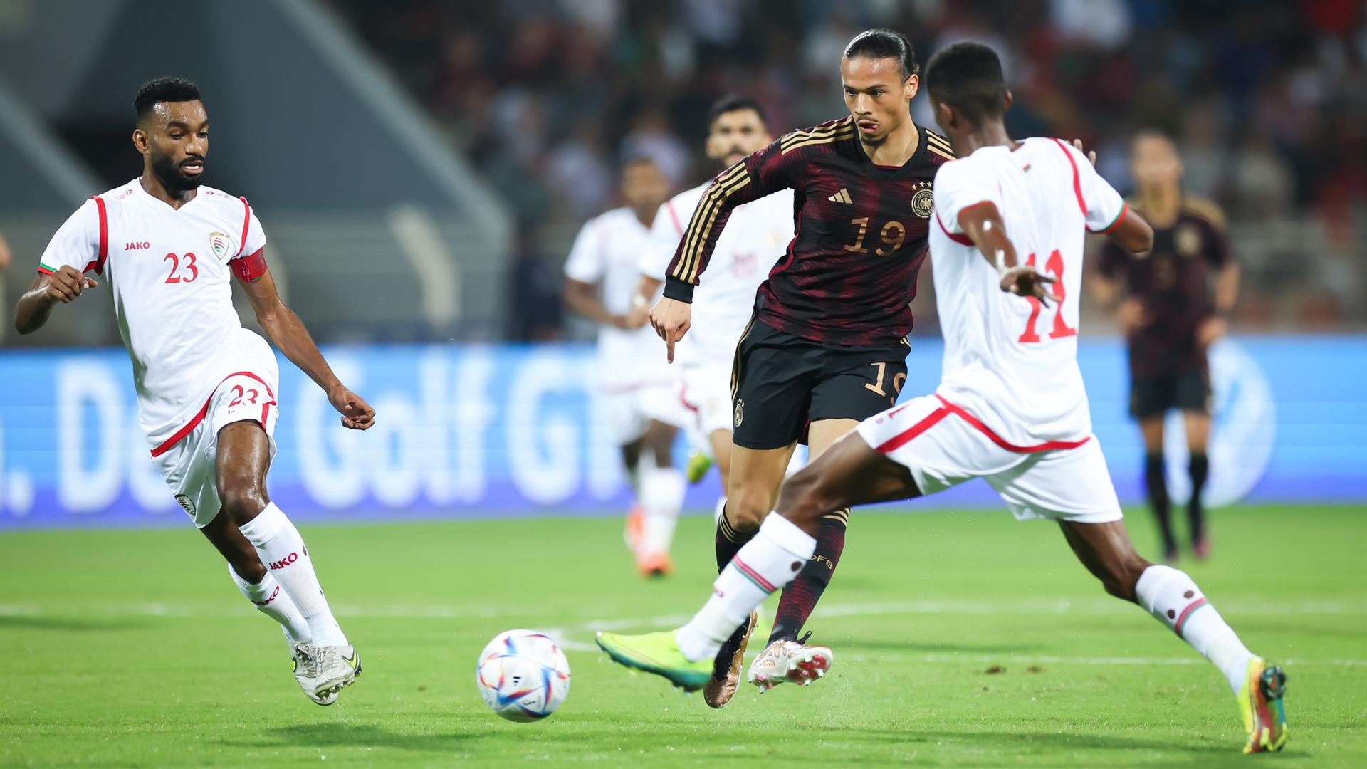 Freundschaftsspiel zwischen Deutschland und Oman vor der Fußball-WM in Katar: Deutschlands Leroy Sane (Mitte) passt den Ball gegen Harib Al-Saadi (links) und Amjad al-Harthi (rechts). Freundschaftsspiel zwischen Deutschland und Oman vor der Fußball-WM in Katar: Deutschlands Leroy Sane (Mitte) passt den Ball gegen Harib Al-Saadi (links) und Amjad al-Harthi (rechts).
