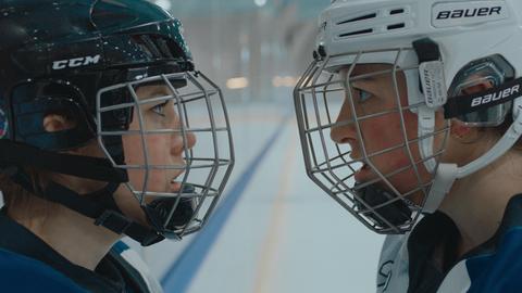 Zwei Eishockeyspielerinnen stehen sich gegenüber und fixieren einander mit Blicken.