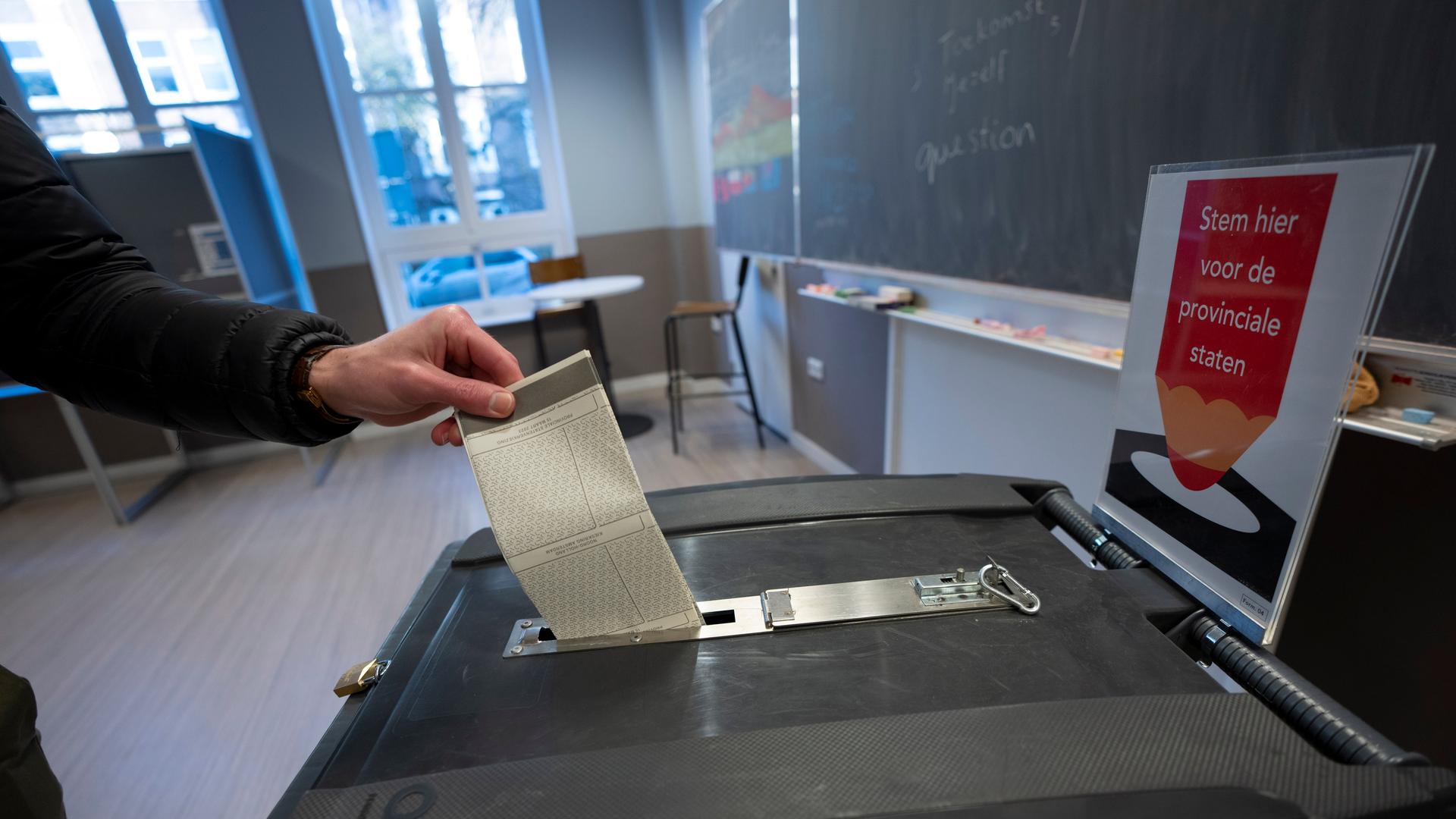 Ein Mann in den Niederlanden gibt seinen Stimmzettel für die Provinzwahlen ab.
