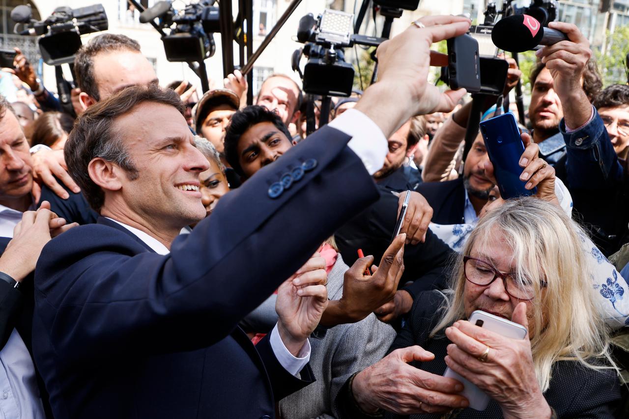 Frankreichs Präsident Emmanuel Macron macht in einer Menschenmenge ein Selfi. Frankreichs Präsident Emmanuel Macron macht in einer Menschenmenge ein Selfi.