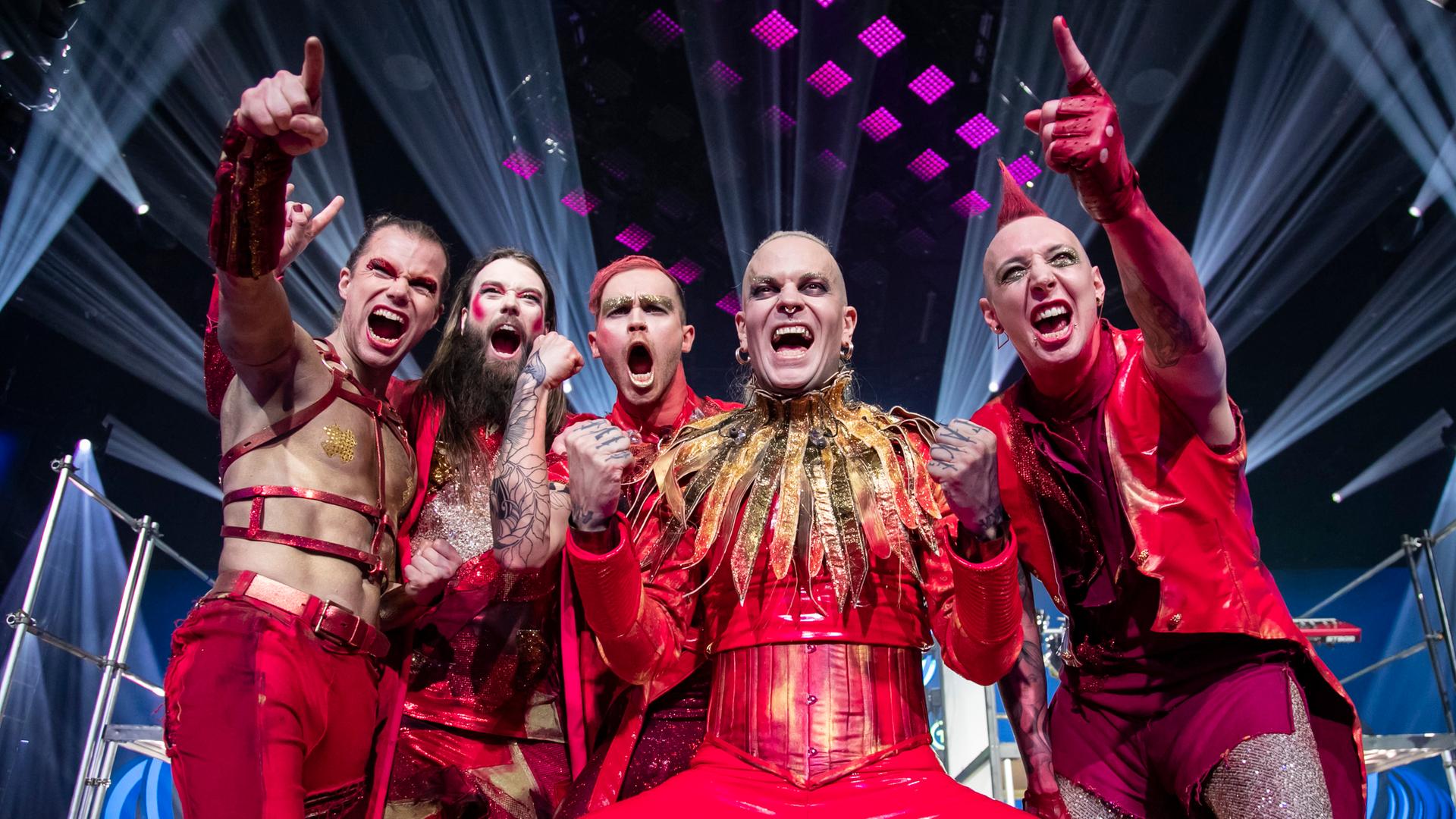 Das Foto zeigt die fünf Mitglieder der Band Lord of the Lost in roter Kleidung auf der Bühne. Das Foto zeigt die fünf Mitglieder der Band Lord of the Lost in roter Kleidung auf der Bühne.