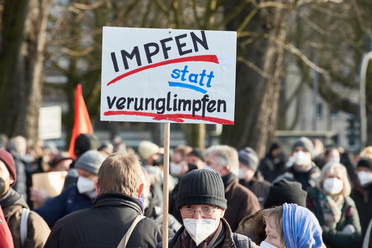 Ein Teilnehmer einer Demonstration hält ein Transparent mit der Aufschrift "Impfen statt verunglimpfen!" auf der Mohrweide am Dammtorbahnhof in Hamburg. Ein Teilnehmer einer Demonstration hält ein Transparent mit der Aufschrift "Impfen statt verunglimpfen!" auf der Mohrweide am Dammtorbahnhof in Hamburg.