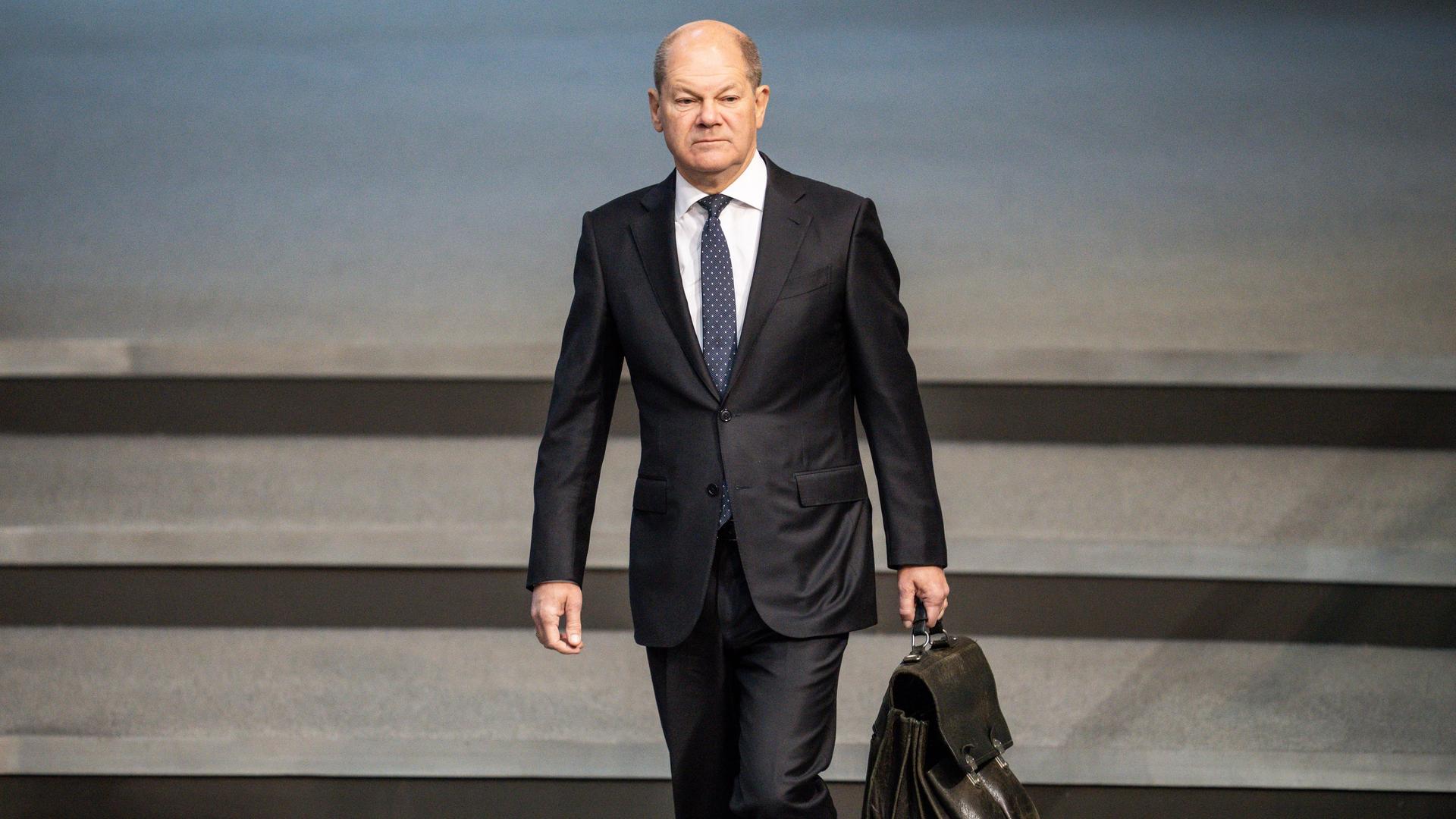 Bundeskanzler Olaf Scholz (SPD). Ein Mann läuft mit einer Aktentasche eine Treppe entlang. Bundeskanzler Olaf Scholz (SPD). Ein Mann läuft mit einer Aktentasche eine Treppe entlang.