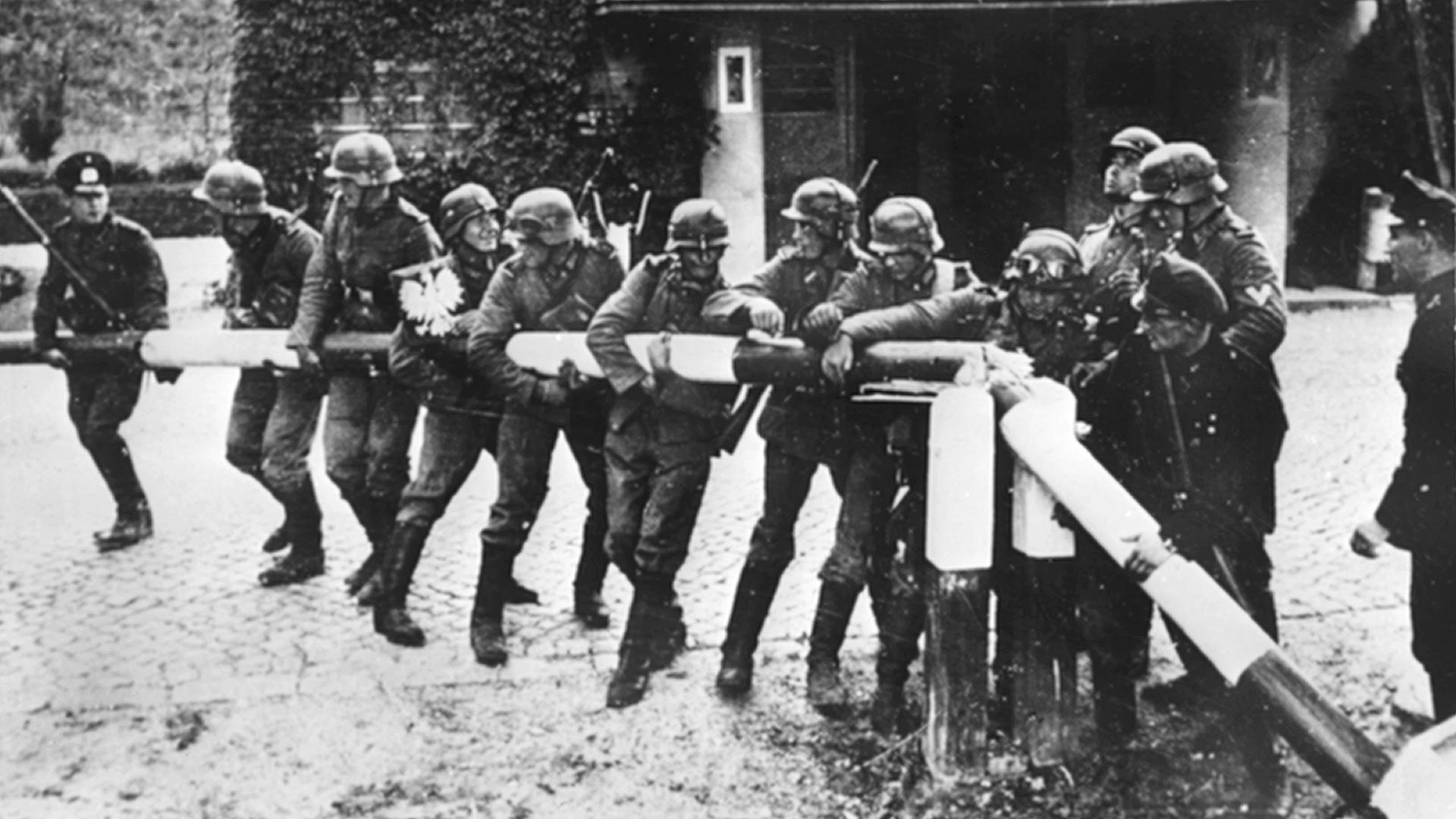 Beim Einmarsch deutscher Truppen in Polen am 1.9.1939 reißen Soldaten der deutschen Wehrmacht einen Schlagbaum an der deutsch-polnischen Grenze nieder. Beim Einmarsch deutscher Truppen in Polen am 1.9.1939 reißen Soldaten der deutschen Wehrmacht einen Schlagbaum an der deutsch-polnischen Grenze nieder.