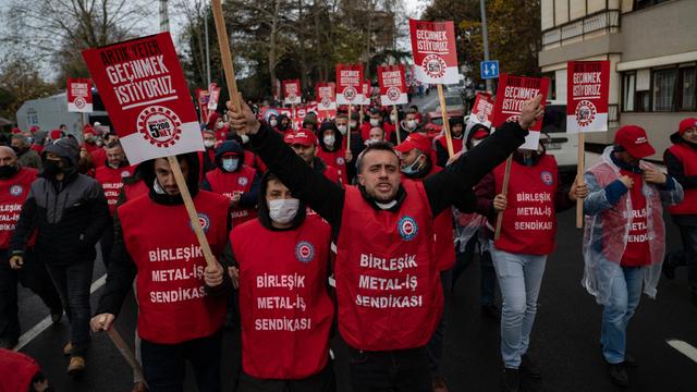 Protestierende mit Bannern und Slogans der Gewerkschaften.