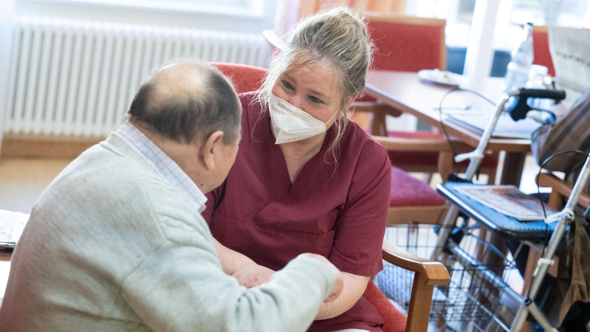 Eine Pflegerin betreut eine Bewohnerin eines Pflegeheims Eine Pflegerin betreut eine Bewohnerin eines Pflegeheims