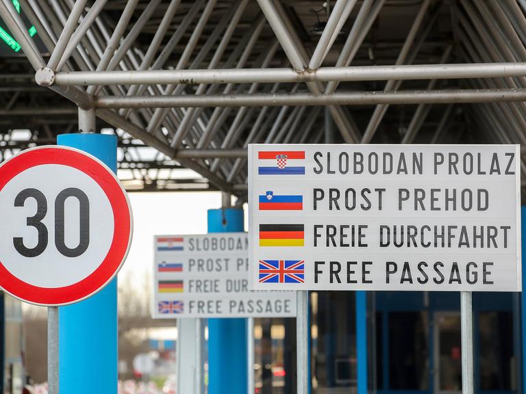 Ein Grenzübergang, an dem ein 30-km-Tempo-Schild neben einem weiteren Schild steht, auf dem in vier Sprachen - auch der kroatischen - Freie Durchfahrt steht.