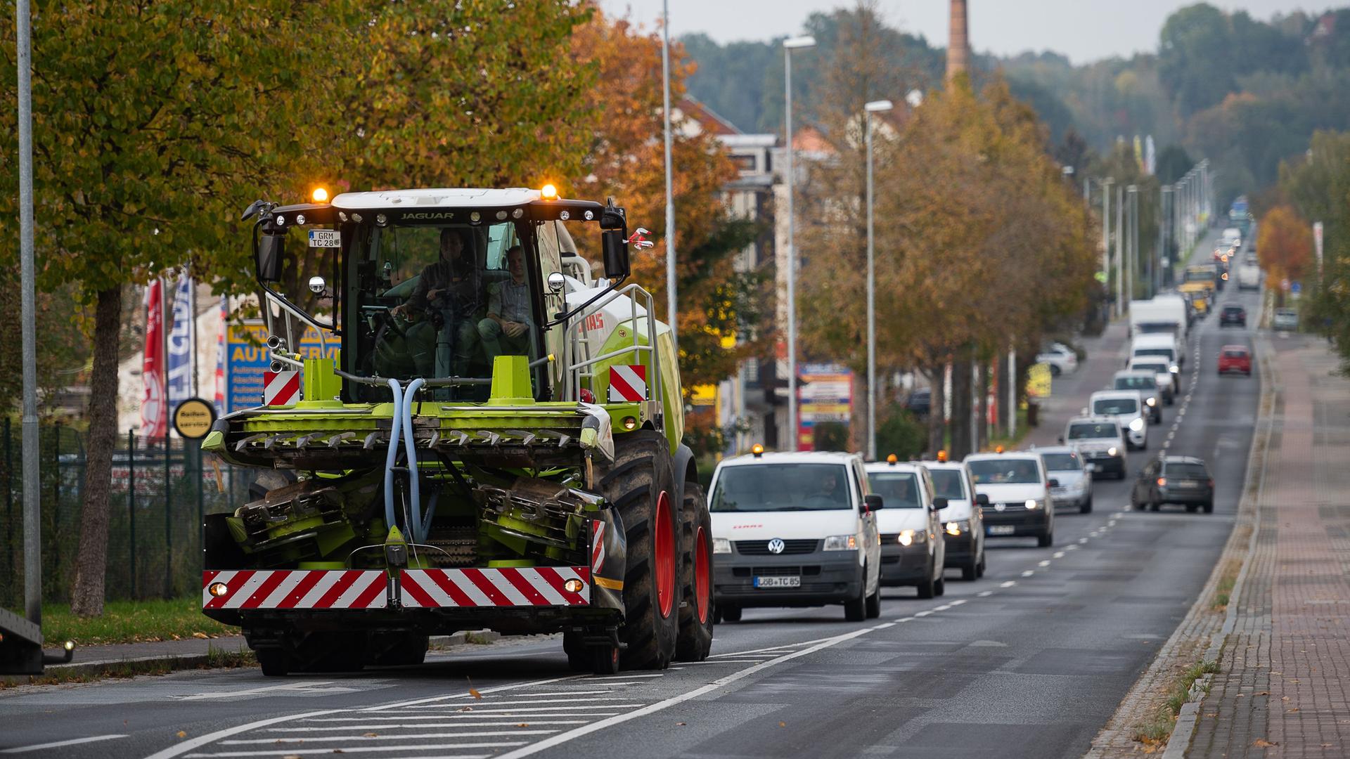 Zittau: Ein Maishäcksler, Laster, Transporter und Autos fahren in einem Korso auf der Löbauer Straße in Zittau.