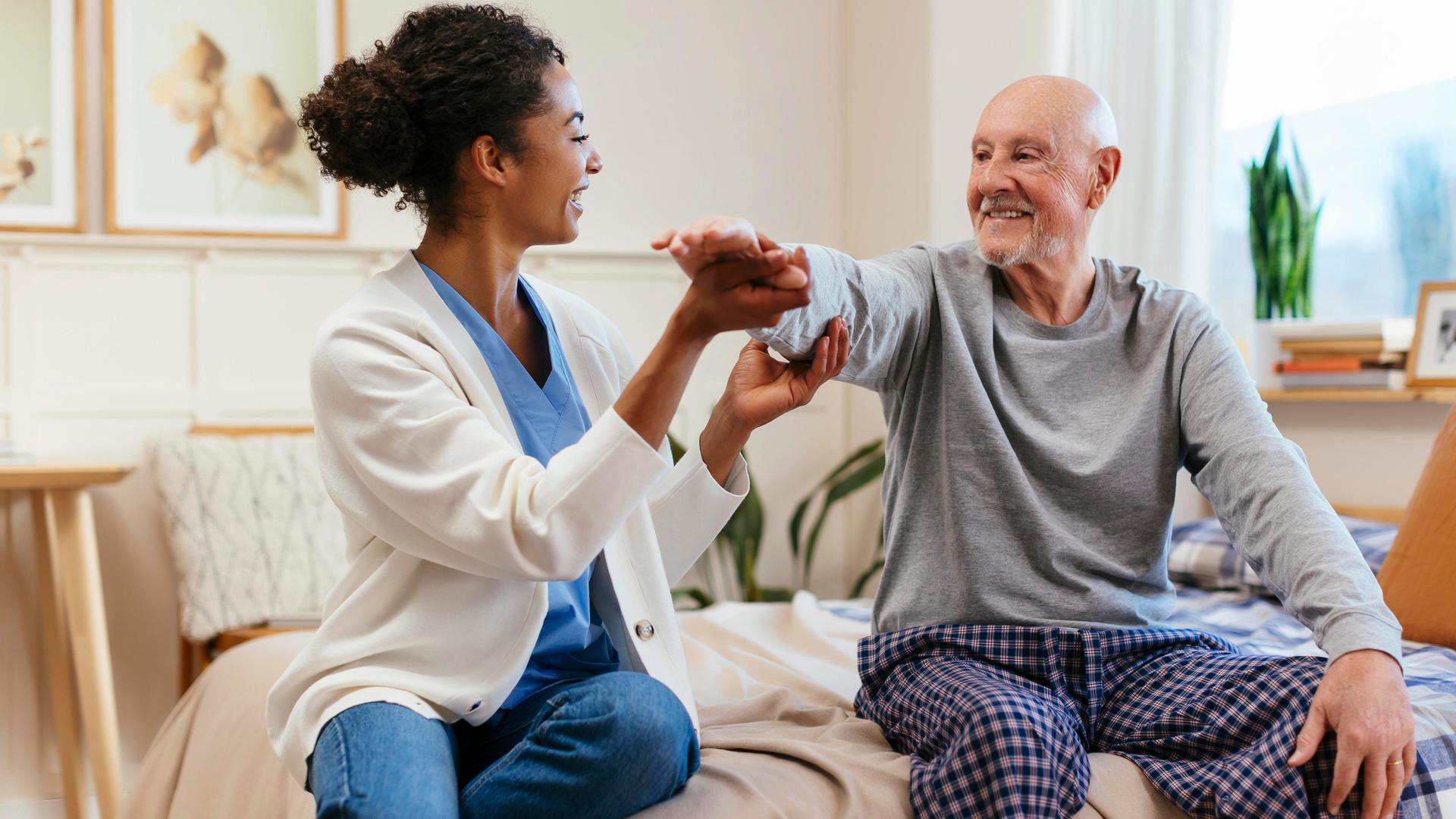 Eine Pflegekraft hat Spaß bei der Arbeit mit ihrem Patienten.