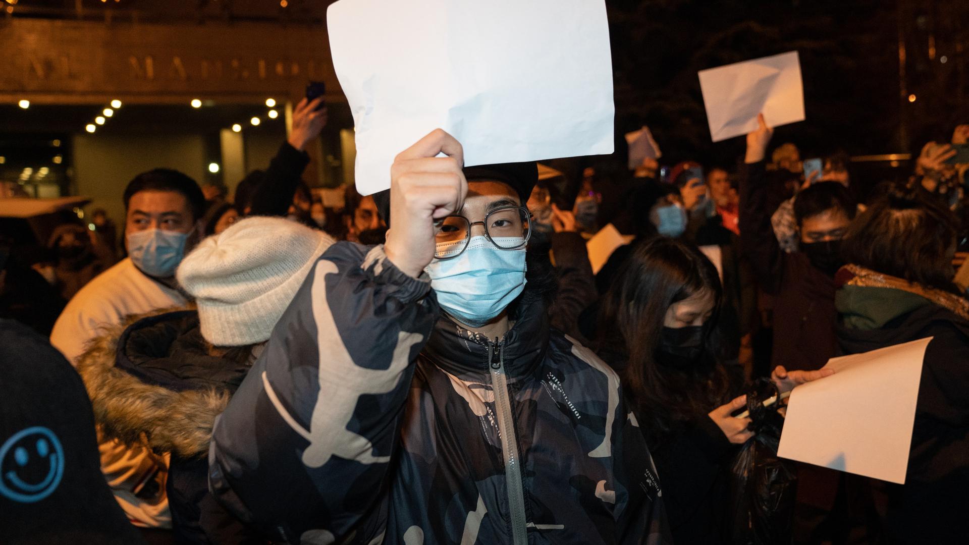 Ein Protestierender in Peking äußert seinen Unmut ohne Worte. Er hält ein weißes Blatt Papier in die Höhe.