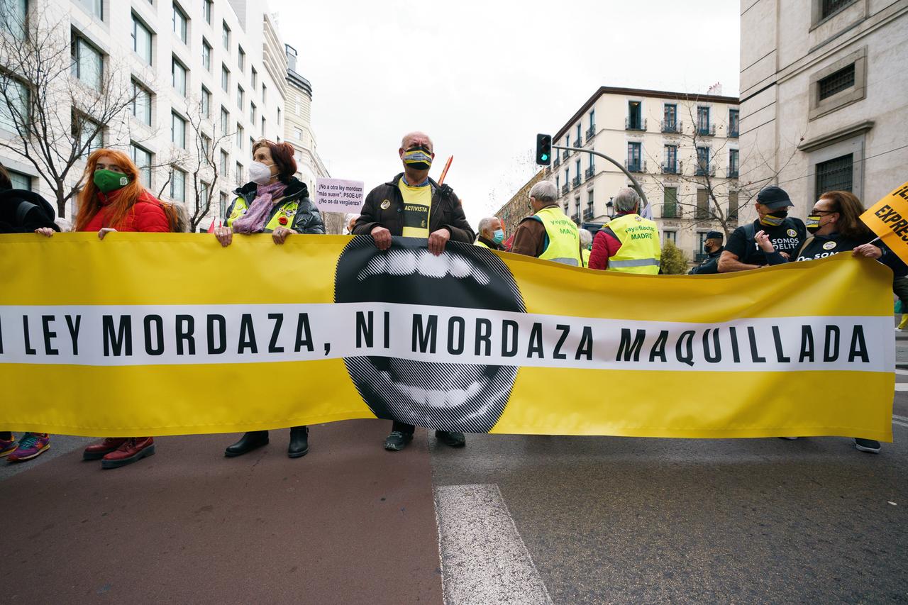 Protestierende laufen mit einem Banner gegen das sogenannte "Maulkorbgesetz" durch die Straßen von Madrid. Protestierende laufen mit einem Banner gegen das sogenannte "Maulkorbgesetz" durch die Straßen von Madrid.