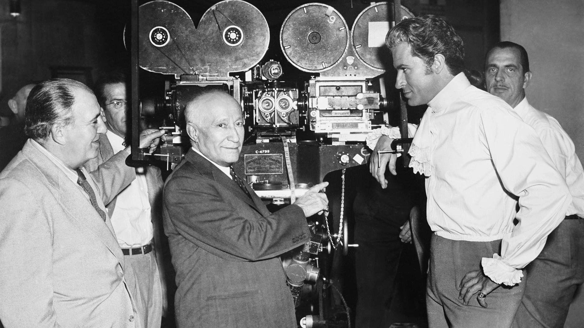 Der Filmproduzent Adolph Zukor steht neben einer Kamera