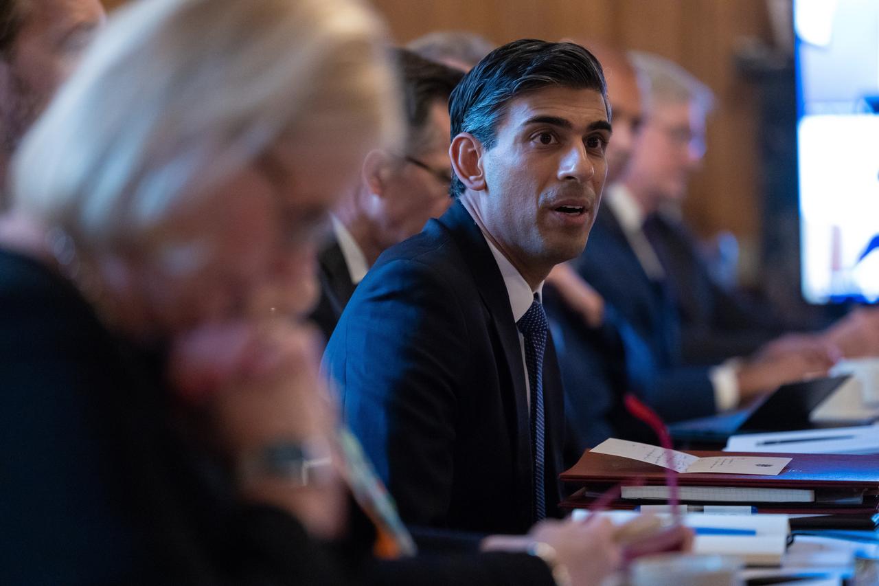 Ein Mann in Anzug mit dunklen Haaren sitzt mit anderen Menschen an einem Tisch: Großbritanniens Premierminister Rishi Sunak. Ein Mann in Anzug mit dunklen Haaren sitzt mit anderen Menschen an einem Tisch: Großbritanniens Premierminister Rishi Sunak.
