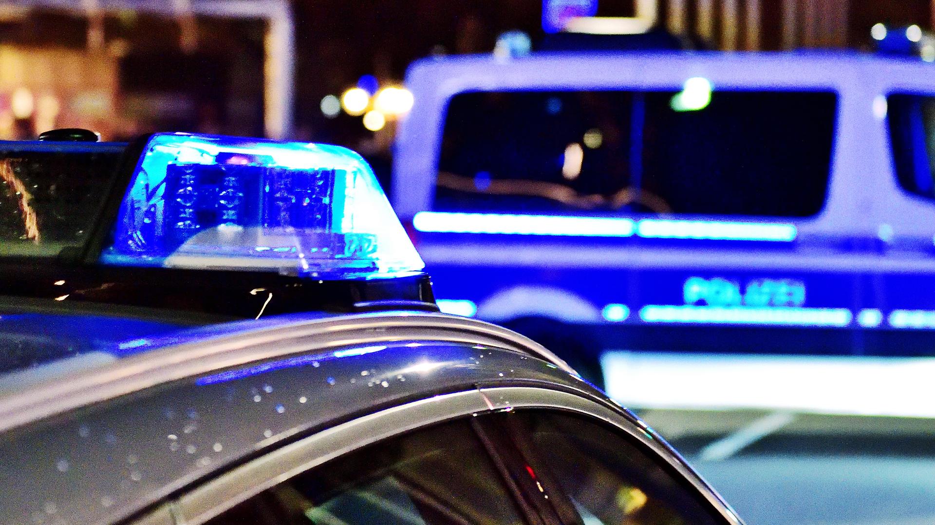 Zwei Polizeiautos mit Blaulicht parken nachts auf der Straße