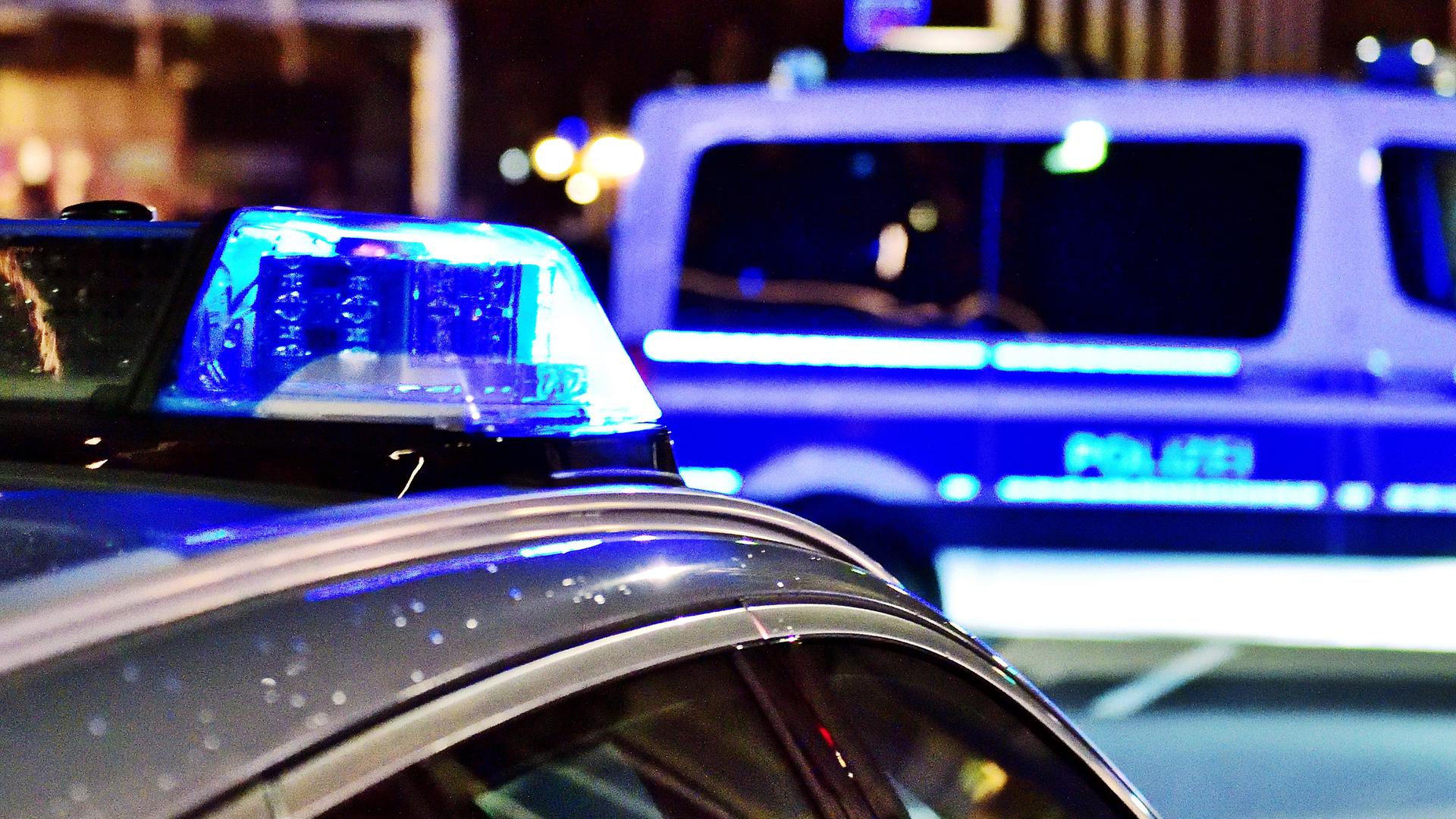 Zwei Polizeiwagen mit Blaulicht stehen nachts auf der Straße Zwei Polizeiwagen mit Blaulicht stehen nachts auf der Straße