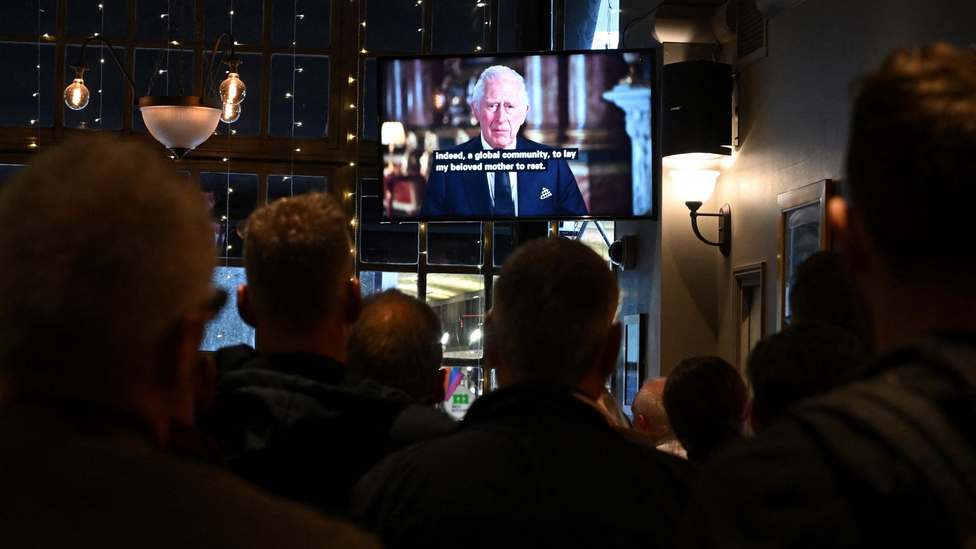 Menschen in einem Pub schauen sich die erste Ansprache des neuen britischen Königs Charles III. an.