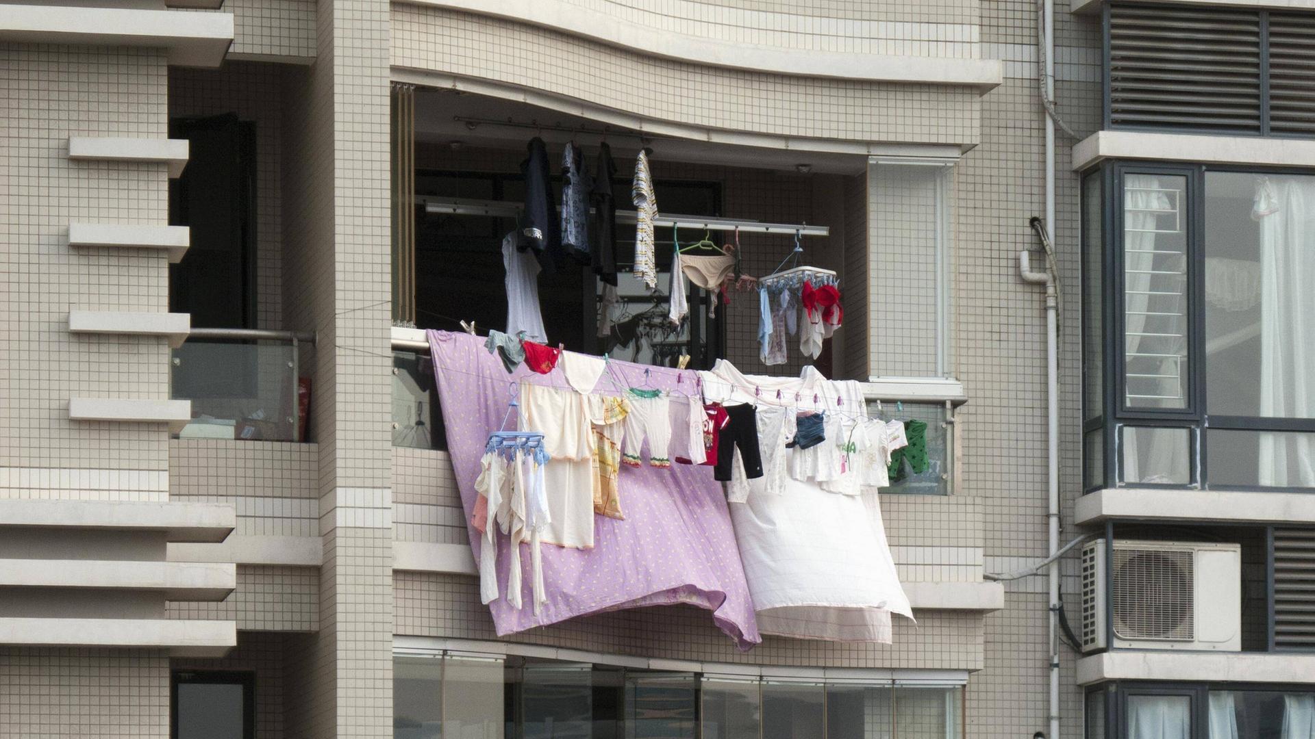 Bunte Wäsche hängt von einem Balkon eines Hochhauses. Bunte Wäsche hängt von einem Balkon eines Hochhauses.